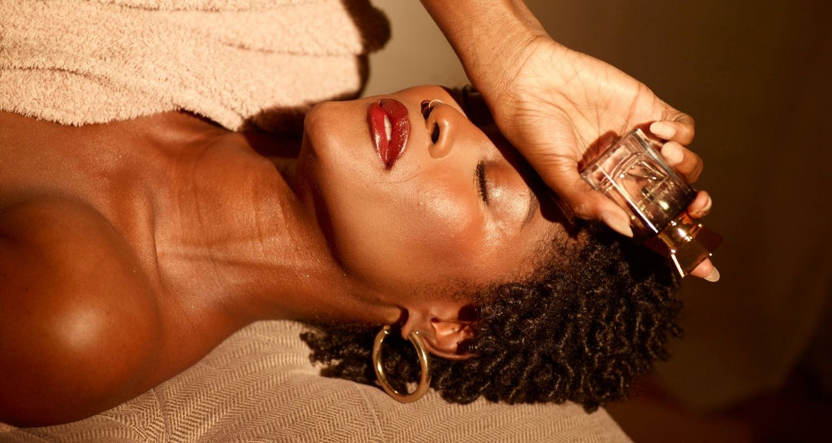 a deep skin woman holding a fine fragrance